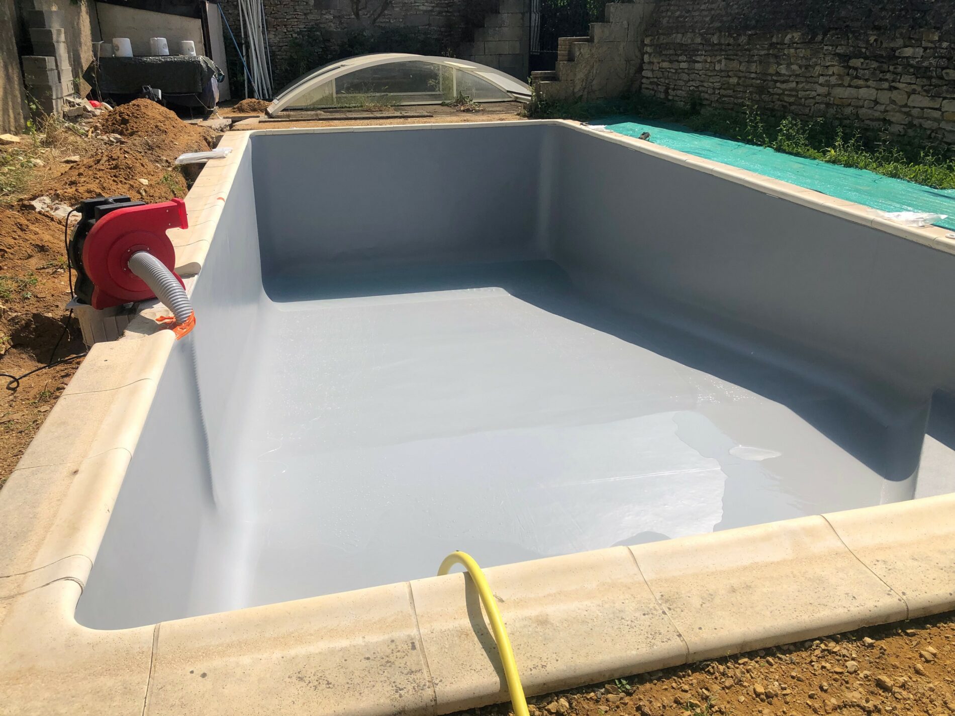 Pose d'un liner gris dans la piscine